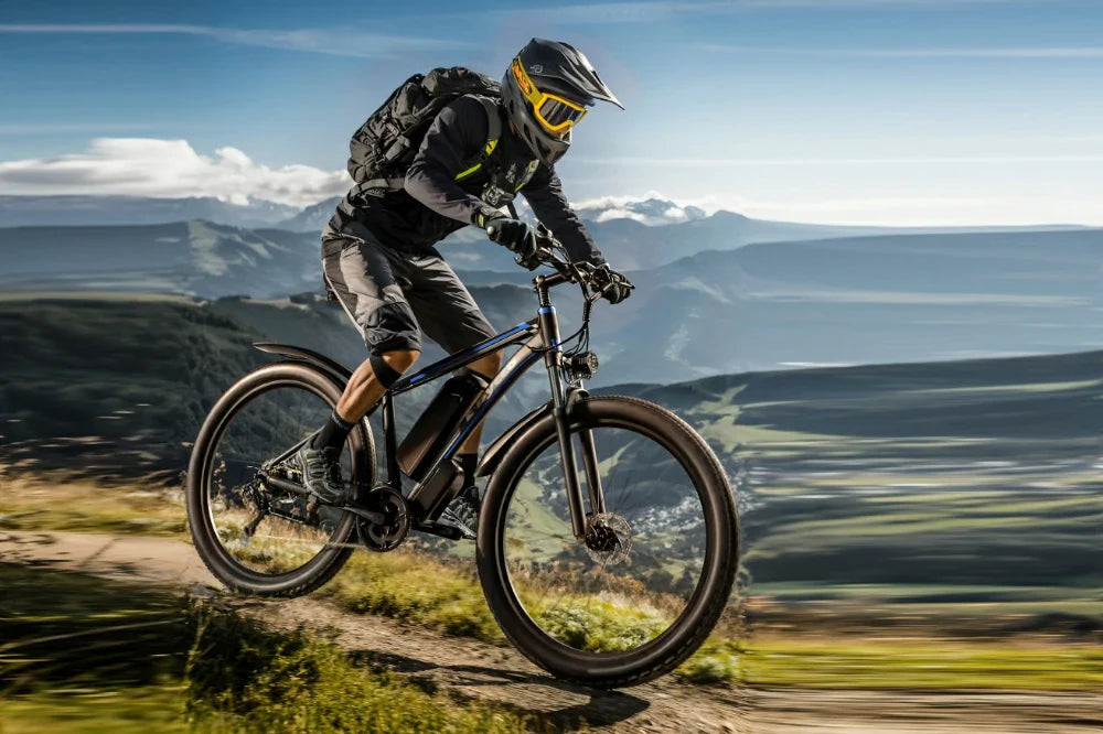 Dynamic mountain trail action shot of fully geared rider jumping black blue E-BYCCO E8 fat tire electric mountain bike over alpine hillside track.
